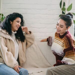 Two people talking while sitting on the couch