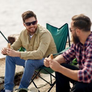Two people talking while sitting outside in camping chairs