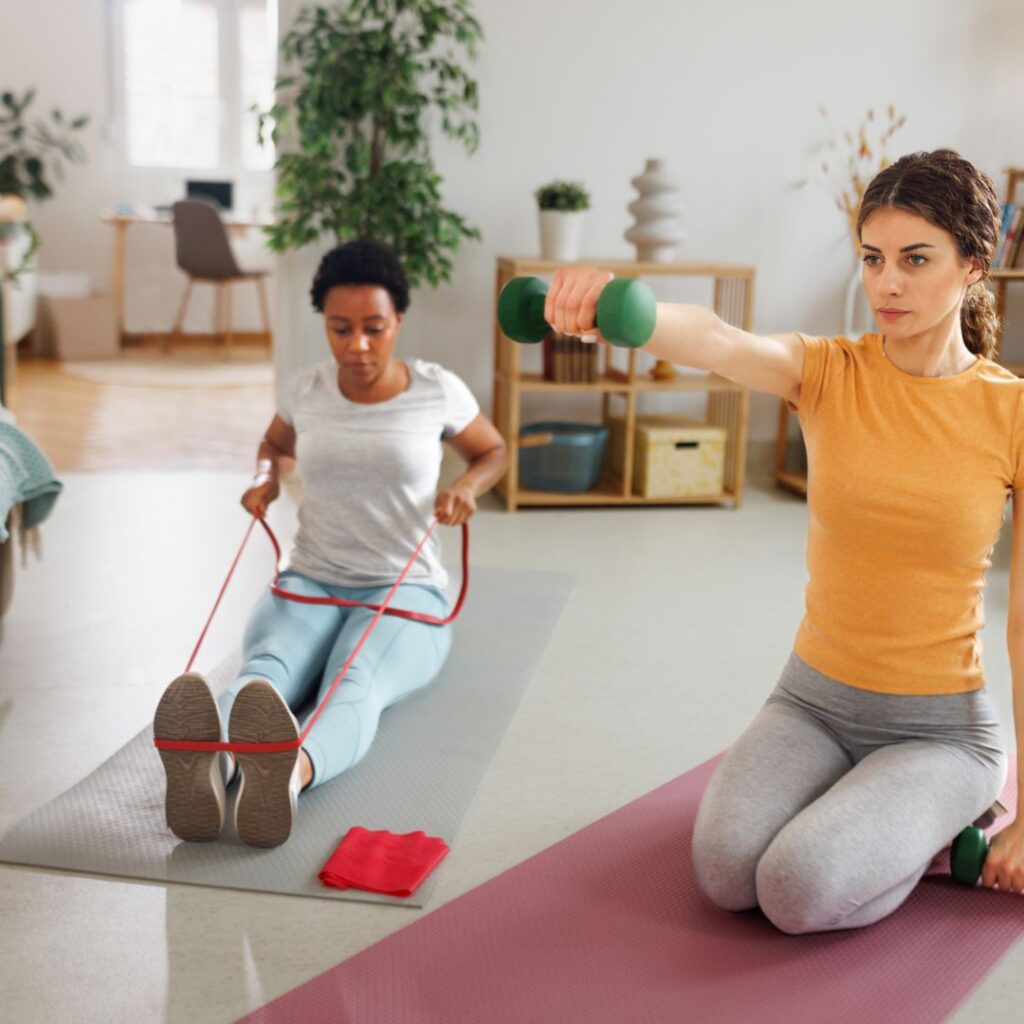 Two women working out with resistant bands and dumbbells