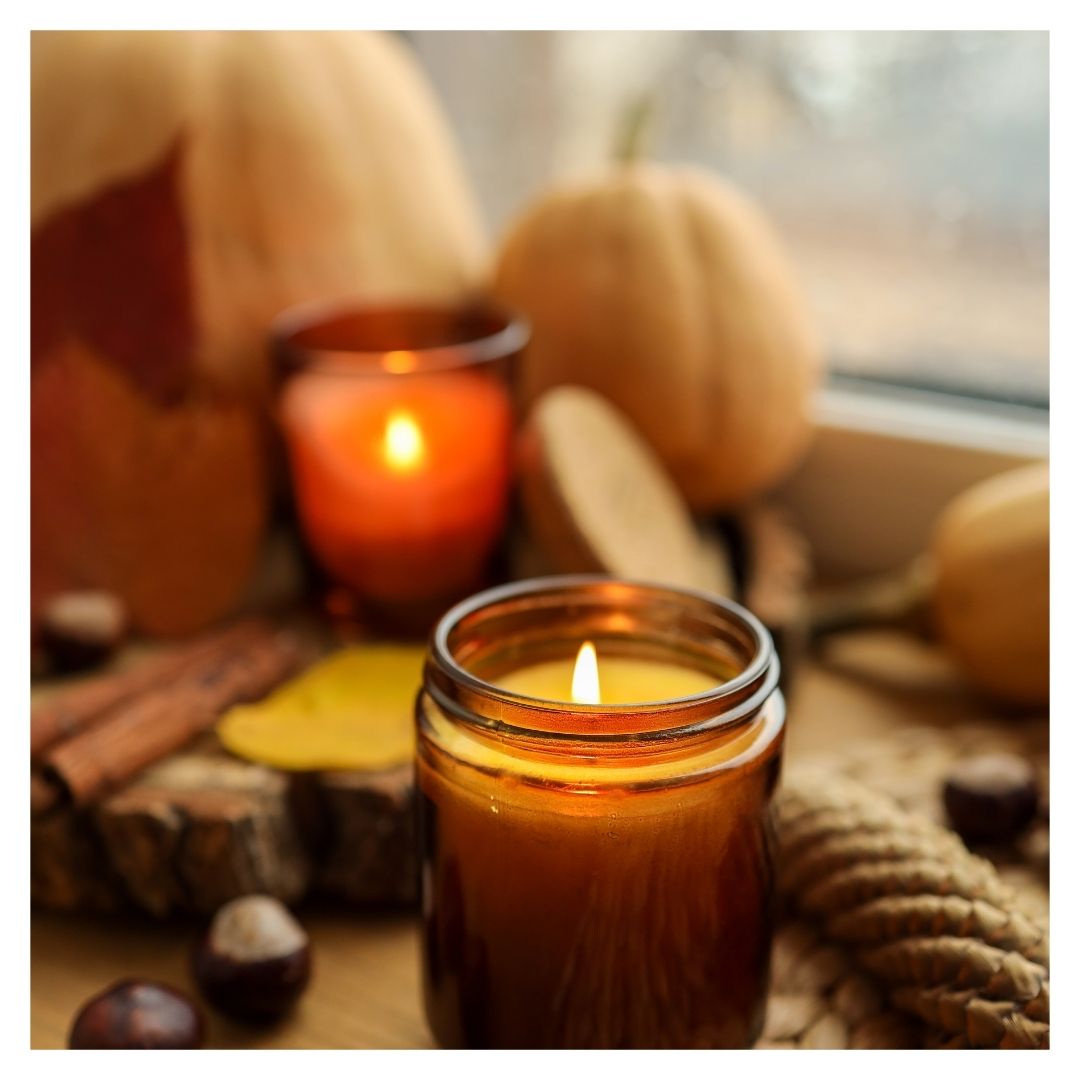 a lit candle and fall decor