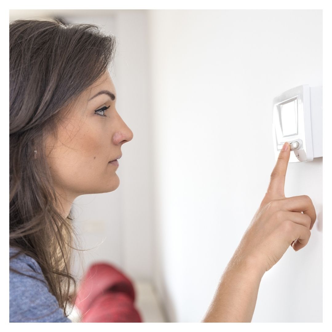 woman checking thermostat