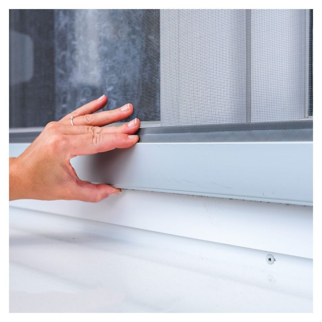 person checking for window drafts