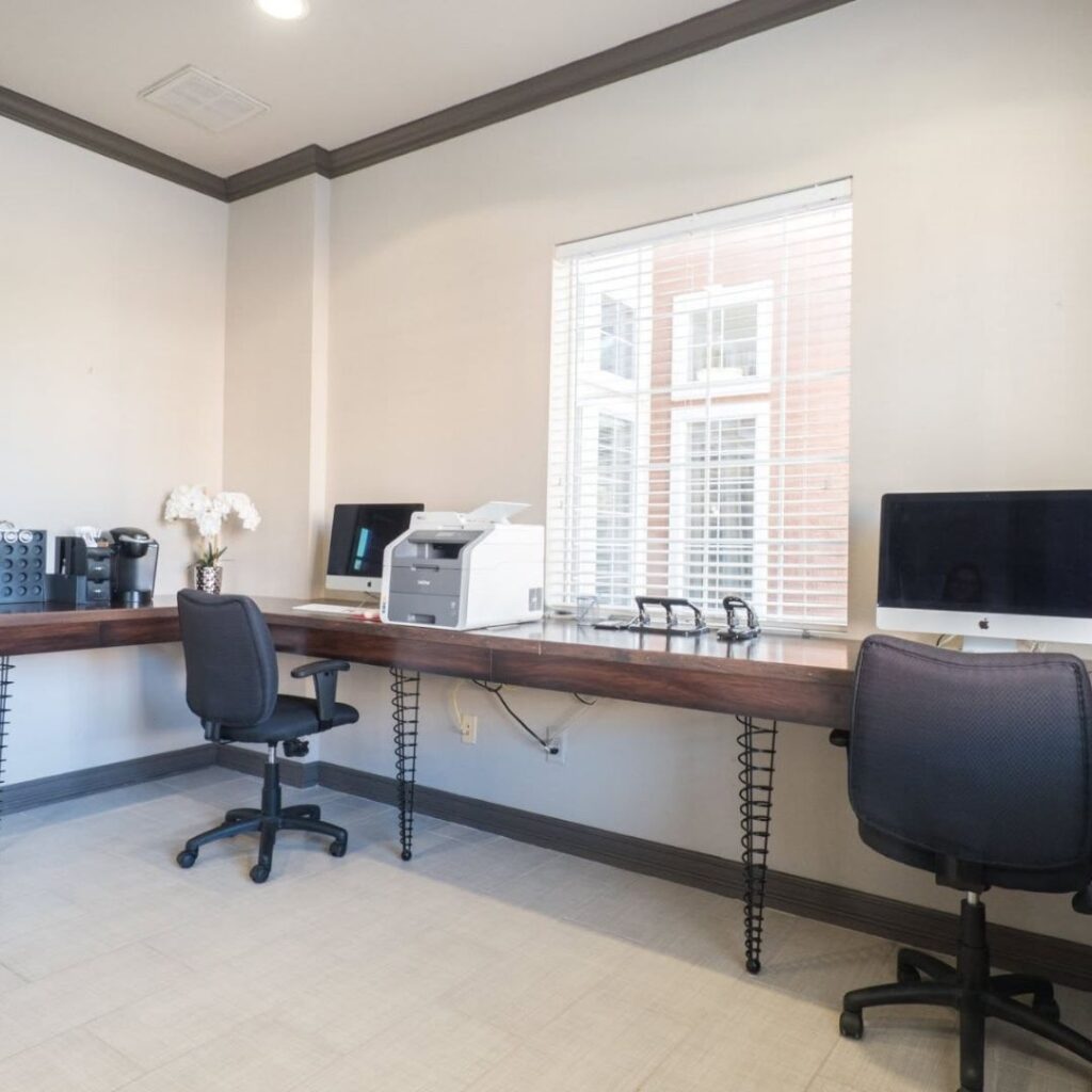 An inviting, modern apartment clubhouse with distinct remote working stations and comfortable seating.